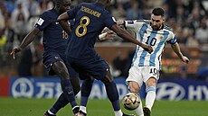 Argentinský kapitán Lionel Messi je bránn Dayotem Upamecanem a Aurelienem...