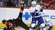 Radim Zohorna (v erném) z Calgary padá na led v zápase s Vancouverem.
