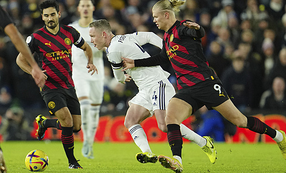 Adam Forshaw (uprosted) z Leedsu bránný Erlingem Haalandem z Manchesteru City.