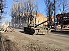Ukrajinský tank T-72 projídí plnou rychlostí kolem barikád v centru Bachmutu...