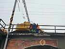 Dlníci pracují na pokozeném most, aby na nj mohli umístit provizorní...