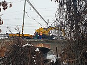 D�lníci pracují na po�kozeném most�, aby na n�j mohli umístit provizorní...