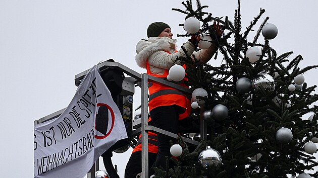 Aktivist skupiny Letzte Generation (Posledn generace) eou piku berlnskho vnonho stromku, kter stoj nedaleko Braniborsk brny. (21. prosince 2022)