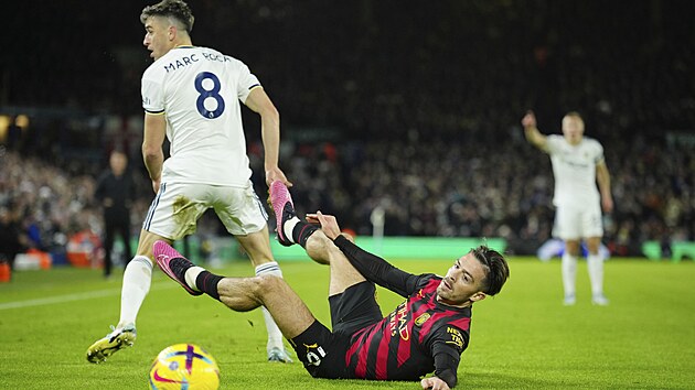 Jack Grealish (le��c�) z Manchesteru City sleduje m�� po souboji s Marcem Rocou z Leedsu.