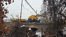 D�lníci pracují na po�kozeném most�, aby na n�j mohli umístit provizorní...