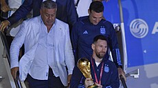 Lionel Messi z pohárem pro mistry svta vystupuje z letadla v Buenos Aires.