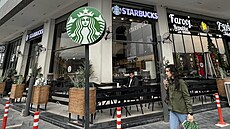 �ena prochází kolem neoficiální kavárny Starbucks v Bagdádu. (21. prosince 2022)