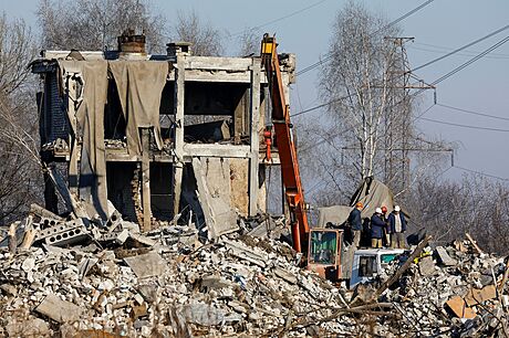 Po ukrajinském zásahu. Dlníci odstraují trosky bývalé koly, kterou jako svou...