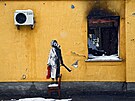 Banksyho dílo na zdi pokozeného domu v ukrajinském Hostomelu (26. listopadu...
