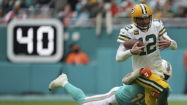 Aaron Rodgers (12) z Green Bay Packers to v zpase s Miami Dolphins, polapit se ho sna Jaelan Phillips.