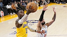Dennis Schröder (vlevo) z Los Angeles Lakers zakon�uje na ko� Miami Heat, brání...