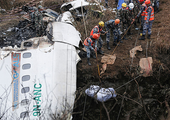 Záchranný tým vyzvedává tlo obti z místa letecké havárie v Nepálu. (16. ledna...