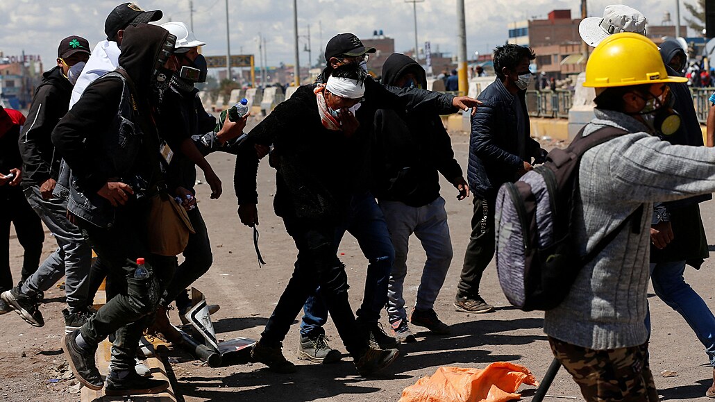 Demonstranti pomáhají zrannému mui bhem stetu s bezpenostními silami pi...