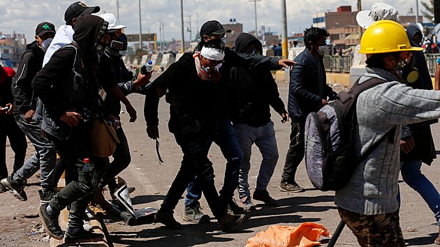 Demonstranti pomáhají zrannému mui bhem stetu s bezpenostními silami pi...