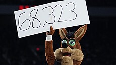 Maskot San Antonia The Coyote drí ceduli s potem divák na zápase proti...