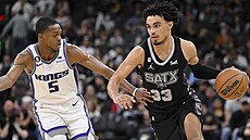 Tre Jones (33) ze San Antonio Spurs najídí ke koi Sacramento Kings, brání ho...