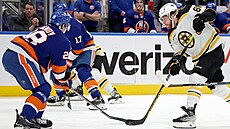 David Pastrňák (88) z Boston Bruins pálí na bránu New York Islanders, brání ho...