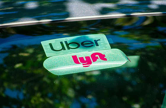 Logo společností Lyft a Uber na samolepce čelního skla jednoho z vozidel (19....
