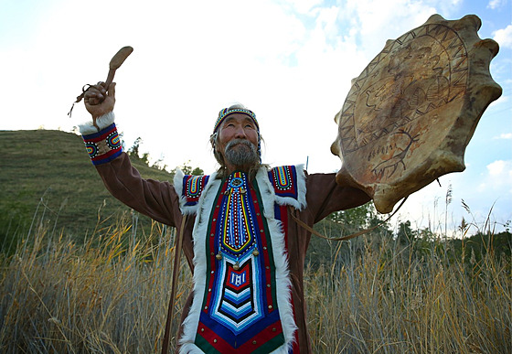 Jakutský muž v tradičním místním oděvu a s šamanským bubnem