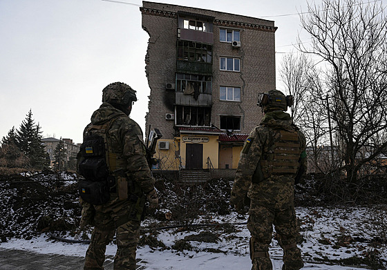 Ukrajintí vojáci stojí ped obytnou budovou v Bachmutu, kterou zniila ruská...