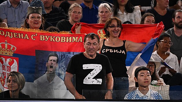 Mu v triku s npisem "Z" sleduje tvrtfinlov zpas musk dvouhry mezi Srbem Novakem Djokoviem a Rusem Andrejem Rublem vedle fanouk se srbskmi vlajkami bhem destho dne tenisovho turnaje Australian Open v Melbourne (25. ledna 2023)