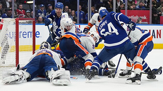 David Kampf (64) z Toronto Maple Leafs se tla do brny v zpase s New York Islanders.