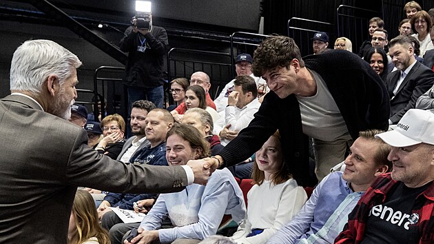 Petr Pavel se v publiku zdrav se svm podporovatelem modertorem Milanem Peroutkou. (25. ledna 2023)