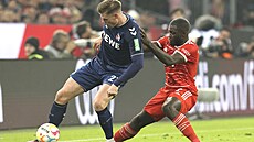 Dayot Upamecano (vpravo) z Bayernu Mnichov brání Steffena Tiggese z Kolína nad...