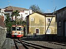 Úzkorozchodný vlak spolenosti Ferrovia Circumetnea projídí kolem bývalého...