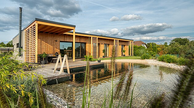 D�m se odr�� v hladin� zahradn�ho jez�rka, kter� je um�st�n� v poloze takzvan�ho prim�rn�ho pal�ce � blahod�rn� energie. V�echny d�ev�n� prvky se �asem barevn� spoj� a zapoj� do ter�nu, v�etn� dubov�ho �eb��ku pro v�lez z vody. 