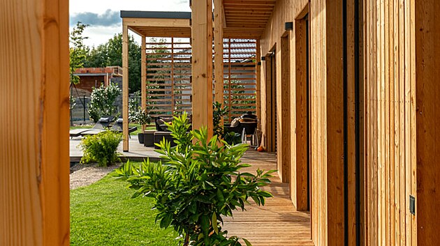 Ji�n� orientace fas�dy vnesla do projektu pot�ebu velk�ho p�esahu st�echy, kter� v l�t� zabra�uje p�eh��v�n� interi�ru a sou�asn� kryje p�ed de�t�m d�ev�n� ochoz, kter� p�ech�z� v oblinu pobytov� terasy.