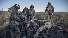 Ukrajinští dobrovolníci sbírají na bitevním poli těla ruských vojáků. (7....