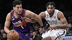 Devin Booker (1) z Phoenix Suns najídí na ko Brooklyn Nets, brání ho Cam...