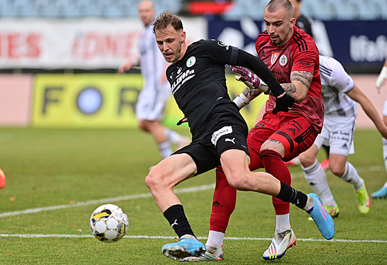 Útoník David Puká z Bohemians (vlevo) s míem ped brankáem Martinem...