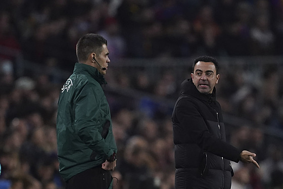 Barcelonský kou Xavi Hernandez debatuje se tvrtým rozhodím bhem zápasu...