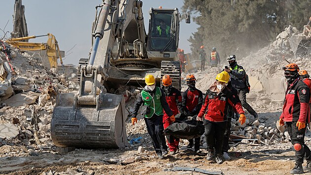 Záchranáři odnášejí tělo mrtvého na místě zřícené budovy. (18. února 2023)