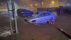Voda z porueného potrubí zaplavila parkovit ve Fialkové ulici v Trutnov....