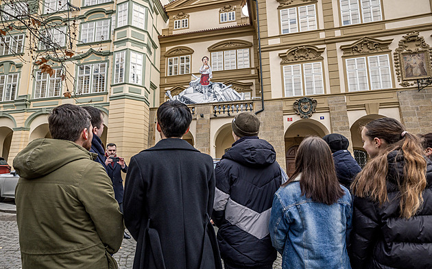 Dívka zpívající na vraku auta. Malba na fasádě Sněmovny symbolizuje naději
