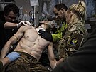 Ukrajinský vojenský zdravotník oetuje v polní nemocnici u Bachmutu zranného...
