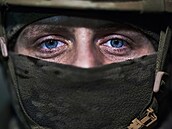 Ukrajinský voják vyhlíží z úkrytu v Bachmutu. (21. února 2023) 