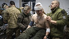 Ukrajinský vojenský zdravotník o�et�uje v polní nemocnici u Bachmutu zran�ného...