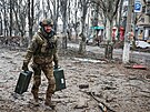 Ukrajinský voják pronáí zbran na prázdnou ulici Bachmutu. (25. února 2023)