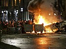 Demonstranti u hoícího policejního auta nedaleko budovy gruzínského parlamentu...