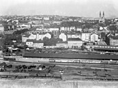 Pohled přes smíchovské nádraží na Vyšehrad s kostelem sv. Petra a Pavla, vlevo...