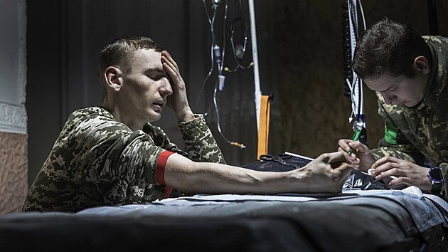 Zdravotnk poskytuje prvn pomoc zrannmu ukrajinskmu vojkovi pobl Bachmutu, msta nejt잚ch boj s ruskmi jednotkami. (27. nora 2023)