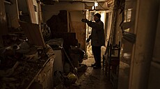 Mu stojí uvnit pokozeného domu své matky v Kupjansku na Ukrajin. (20. února...