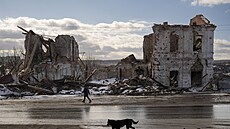 ena prochází kolem budovy zniené ruským úderem v ukrajinském Kupjansku. (20....