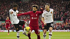 Liverpoolský forvard Mohamed Salah se pokou�í projít kolem dua z Manchesteru...