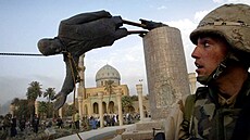 Americký voják Kirk Dalrymple sleduje svrení sochy Sadáma Husajna v centru...