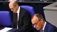 Šéf CDU Friedrich Merz a v pozadí kancléř Olaf Scholz v Bundestagu (17. března...